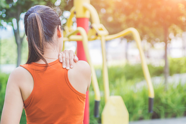 Young asian woman feel pain on her neck and shoulder while exercising, health care concept.
